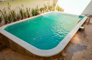 lindo casa natação piscina com cristal Claro águas. cristal Claro casa natação piscina em uma ensolarado dia, conceito do casa natação piscina desenhos foto