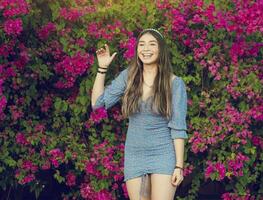 retrato do uma fofa latim menina sorridente dentro uma jardim, fofa jovem Castanho latim menina sorridente dentro a jardim foto