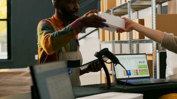 masculino trabalhador preparando caixas com bens para varejo loja entrega, verificação Lista do ordens para logística. jovem adulto carregando pacotes com mercadoria dentro armazenamento sala, qualidade ao controle. foto