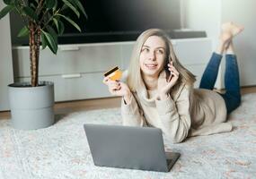 jovem mulher segurando crédito cartão e usando computador portátil computador. foto