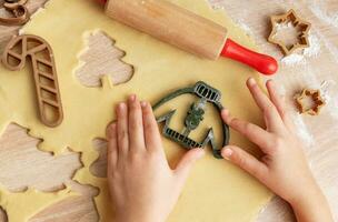 crianças mãos com Pão de gengibre biscoitos em de madeira fundo foto