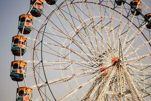 fechar-se do multicolorido gigante roda durante dussehra mela dentro Délhi, Índia. inferior Visão do gigante roda balanço. roda gigante com colorida cabines durante dia tempo. foto