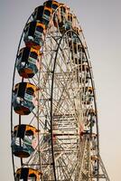 fechar-se do multicolorido gigante roda durante dussehra mela dentro Délhi, Índia. inferior Visão do gigante roda balanço. roda gigante com colorida cabines durante dia tempo. foto