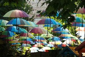 arco Iris guarda-chuva em céu fundo. muitos colorida guarda-chuvas. foto