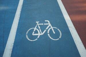 bicicleta símbolo em a azul estrada superfície foto