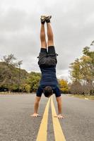 homem fazendo parada de mão no meio da estrada foto