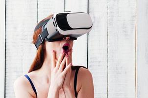 garota de óculos VR, animada, segurando o rosto com as mãos foto