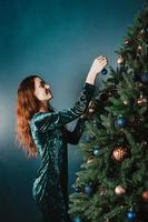 mulher sorridente atraente decorando árvore de natal foto
