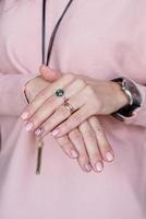 mão feminina com manicure rosa pastel recém-feita foto