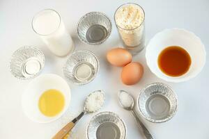 ingredientes para fazer Bolinho em uma branco fundo. ovos, farinha, gema, sal e manteiga em a mesa, topo Visão foto