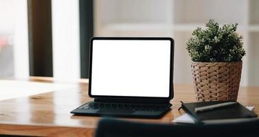 tela em branco do laptop na mesa de madeira com fundo de cafeteria foto