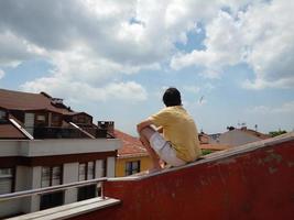 homem sentado no telhado