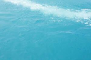 ondas do mar na onda do mar espirrando água da ondulação. fundo de água azul. deixe espaço para escrever o texto. foto