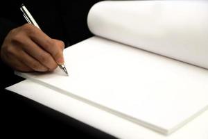 mão do empresário com caneta, mão com caneta escrevendo no papel closeup foto