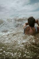 uma mulher natação dentro a oceano foto