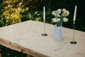 uma mesa com velas e flores em isto manteve ao ar livre foto