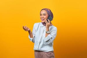 alegre mulher asiática falando com a amiga ao celular foto