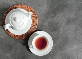 xícara de chá de porcelana branca e bule, configuração de mesa de chá da tarde foto