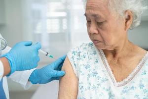 idosa idosa asiática recebendo vacina contra covid-19 ou coronavírus foto