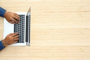 estilo de vida homem fechar acima mão teclado sentar trabalhos em sofá usando uma computador portátil computador para trabalhos a partir de casa e procurar em formação social rede on-line. topo Visão foto