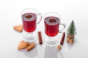 vinho quente tinto quente isolado no fundo branco com especiarias de natal foto