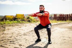 jovem homem é exercício ar livre. ele é fazendo agachamentos. foto