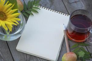 o bloco de notas em branco sobre uma mesa de madeira, lugar para texto. foto