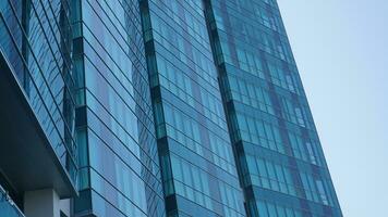 azul vidro construção com céu e nuvem fundo. arranha-céu, Visão do moderno negócio prédio. céu Visão panorama com moderno azul óculos construção foto