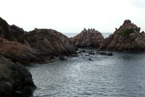 pedras e mar em a Mediterrâneo costa, costa brava Catalana foto