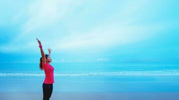 ásia mulheres corrida exercite-se corrida em a de praia dentro a manhã. ampliar a braços relaxar. foto