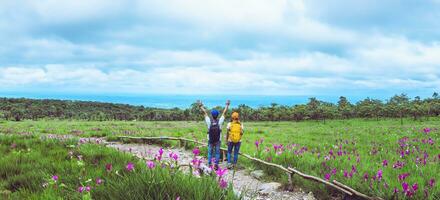 amante mulher e homens asiáticos viajar natureza. viajar relaxar. fotografia campo de flores sessilis de pepino. foto