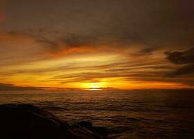 dramático pôr do sol céu com nuvem sobre a mar foto