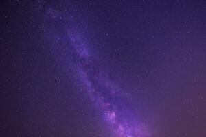 leitoso caminho galáxia dentro Sombrio roxa noite céu foto