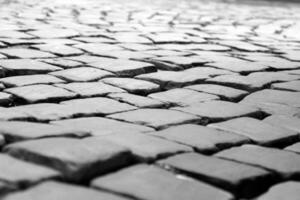 cinzento pedra quadra pavimento. velho tijolo estrada Preto e branco fundo, fechar Visão foto