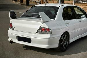 branco carro em uma rua fundo. moderno cidade esporte carro com uma Spoiler papel de parede foto