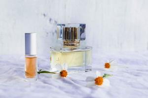 perfume dourado e frascos de perfume em fundo branco foto