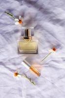 perfume dourado e frascos de perfume em fundo branco foto