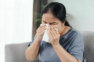 mulher doente tem alergia nasal tossir ou espirrar com lenço de papel. foto