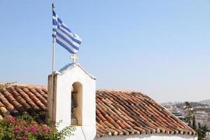 bandeira grega tremulando sobre a cidade de atenas, grécia foto