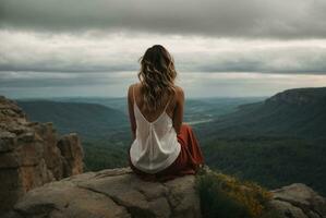 costas Visão do uma mulher sentado sozinho às a grande montanhas. ai generativo foto