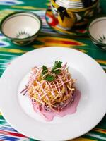 tetraz ninho salada fez do beterraba, torta batatas, Markovi e verdes, coberto com maionese. ásia estilo foto