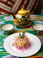 tetraz ninho salada fez do beterraba, torta batatas, Markovi e verdes, coberto com maionese. ásia estilo foto