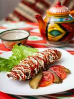 Brizol uma prato do omelete e carne coberto com ketchup e maionese dentro a oriental estilo foto