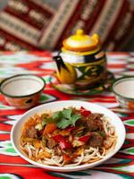 a oriental Lagman prato é caseiro Macarrão frito com carne, legumes e ervas. Oriental cozinha foto