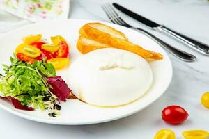 mozzarella com espinafre, cereja tomates, selvagem bagas e pão dentro uma volta prato lado Veiw foto