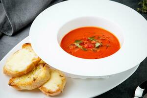 vermelho tomate creme sopa com ervas e torrado pão lado Visão foto