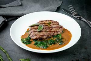 carne bife com molho e ervas em uma branco prato foto