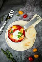 borscht dentro uma fritar panela com fresco pães achatados e cereja tomates topo Visão foto