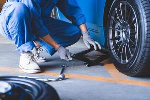 mecânico de automóveis trocando pneu em oficina mecânica foto