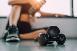 close-up de halteres com exercício de mulher treino em fitness de ginásio foto